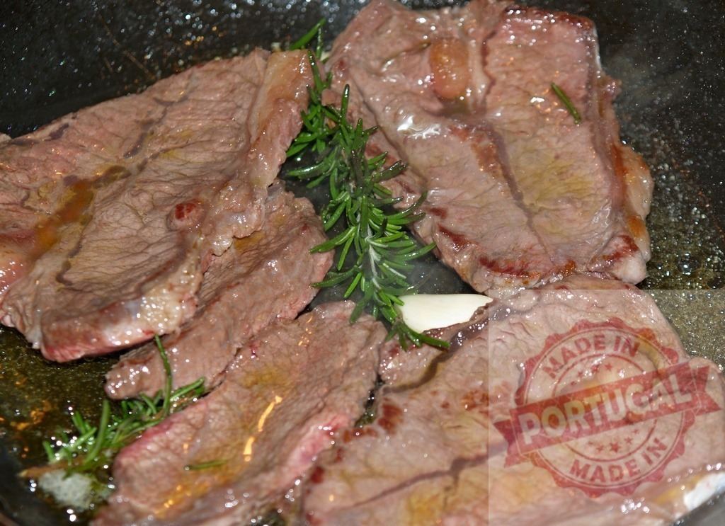 Sizzling beef steaks frying in hot skillet with rosemary | Cooking steaks in a pan with herbs and garlic, preparing a meal - Realized with Pictrs.com