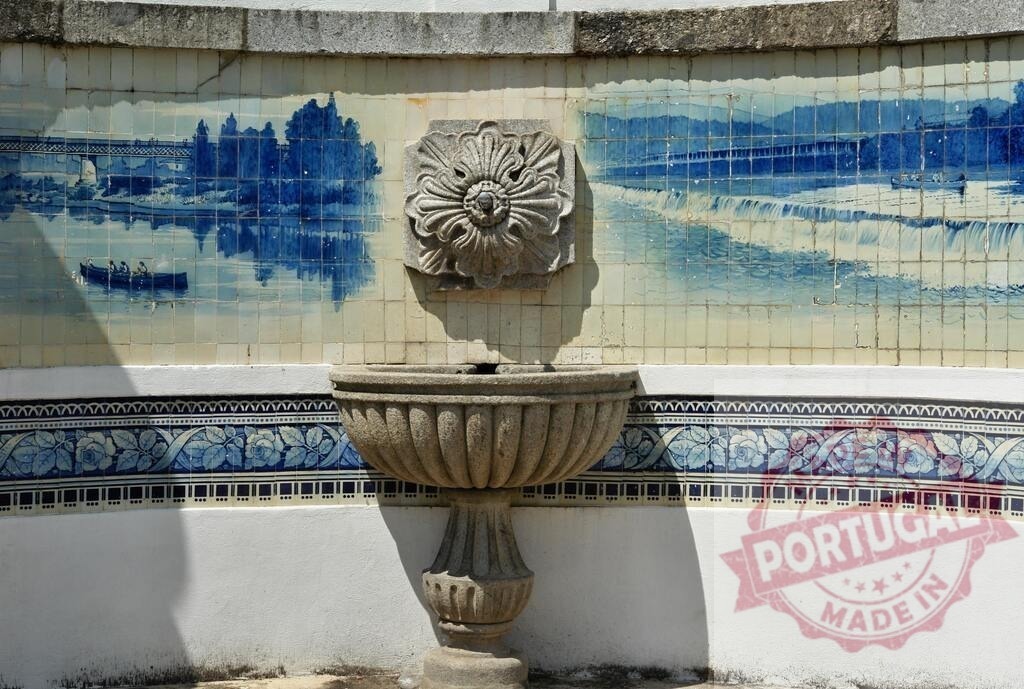 Portuguese azulejo fountain depicting river landscape scene. Portugal - Norte | Stone fountain decorating wall with traditional blue and white azulejo tiles showing a river scene - Realisiert mit Pictrs.com