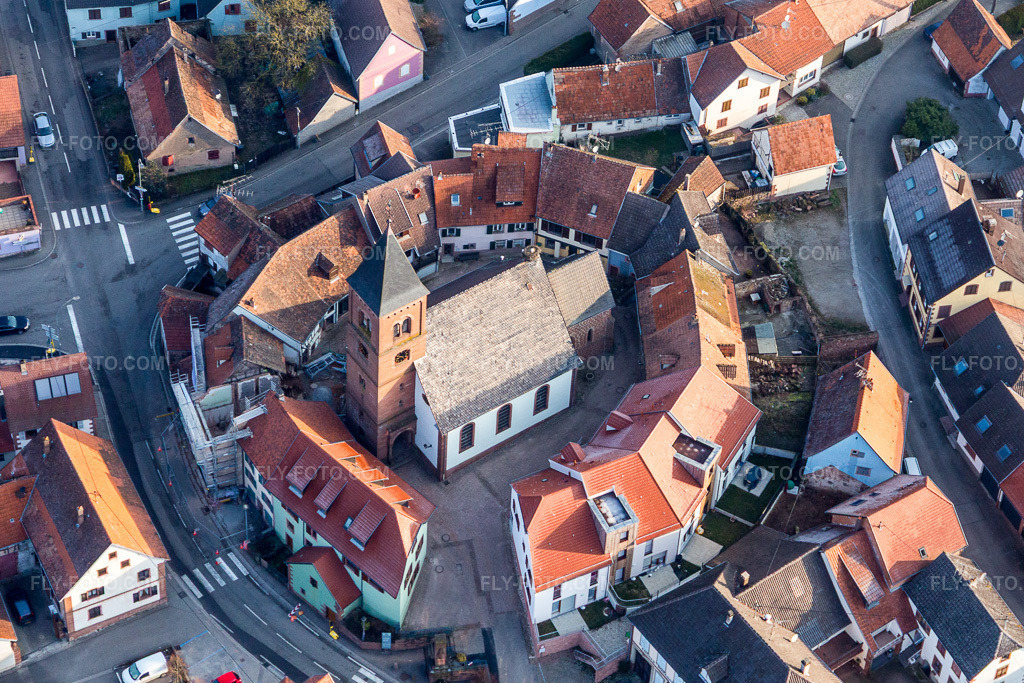 Aerial view: St. Leonhard's Lutheran-Protestant fortified church, surrounded by a ring of houses, is located in the center of the village. in Dossenheim-sur-Zinsel in the state Bas-Rhin, France.Photo: IMG_105335.jpg taken on 03/25/2018 by Werner Riehm/FLY-FOTO.comResolution of the original: 3927 x 2618 px