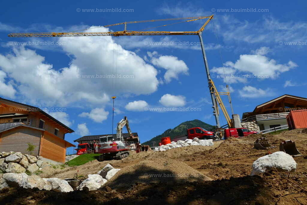 Baukran, Baustellenkran  | Fertig aufgebauter Kran für Baustelle in Hanglage, dahinter blauer Himmel mit weißen Wolken