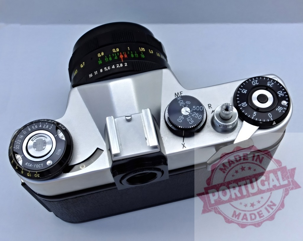 Zenit film camera top view with lens | Vintage analog Zenit SLR film camera with a black lens on a white background - Realized with Pictrs.com