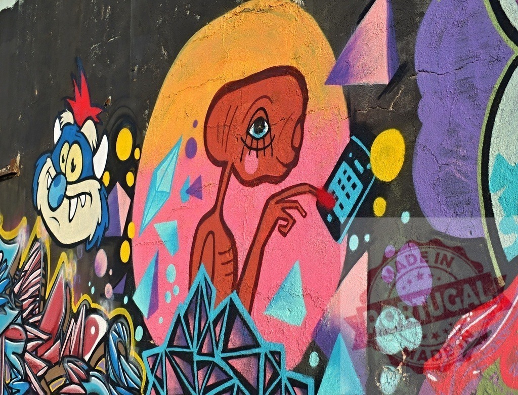 E.T. Street art mural phoning home | Colorful E.T. Graffiti on a wall communicating with an alien device surrounded by abstract shapes - Realized with Pictrs.com