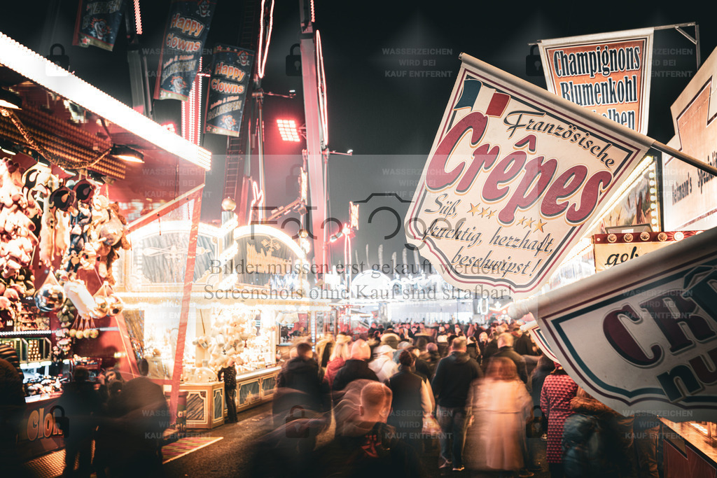 Kirmeslichter und Crêpesduft | Ein Spaziergang über den Jahrmarkt – der Duft von Crêpes liegt in der Luft, bunte Lichter tanzen über den Köpfen der Besucher.Dieses Foto fängt die lebendige Stimmung eines typischen Kirmesabends ein – voller Bewegung, Wärme und Nostalgie. - Realisiert mit Pictrs.com