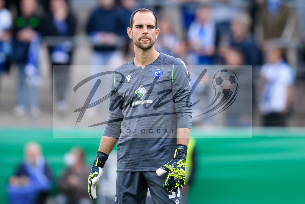 LOTKSC20210809_085 | Fussball, Herren: Torwart Marius Gersbeck (Karlsruher SC) schaut beim Spiel der 1. Runde im DFB-Pokal zwischen SF Lotte und Karlsruher SC im Stadion am Lotter Kreuz am 09.08.2021 in Lotte, Deutschland.DFB / DFL REGULATIONS PROHIBIT ANY USE OF PHOTOGRAPHS AS IMAGE SEQUENCES AND/OR QUASI-VIDEO. - Realisiert mit Pictrs.com