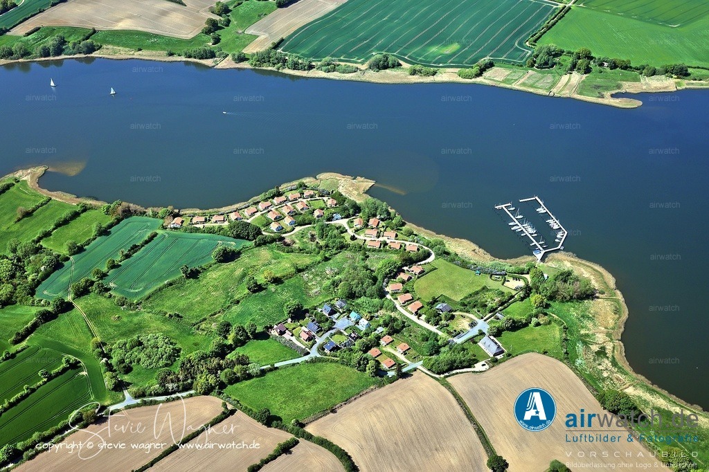 Luftbild Ostseefjord Schlei, Bohnert, Marina Huelsen, Sportboothafen | Marina Hülsen: Das Hafencafé der Marina Hülsen, das sich direkt am Schleiufer befindet, ist ein beliebter Treffpunkt für Wassersportler und Ausflügler. Es bietet frisch gebackene Kuchen, Flammkuchen aus dem Steinbackofen, Weine und frisch gezapftes Bier. Die Außenterrasse ist windgeschützt und lädt zum Verweilen ein.