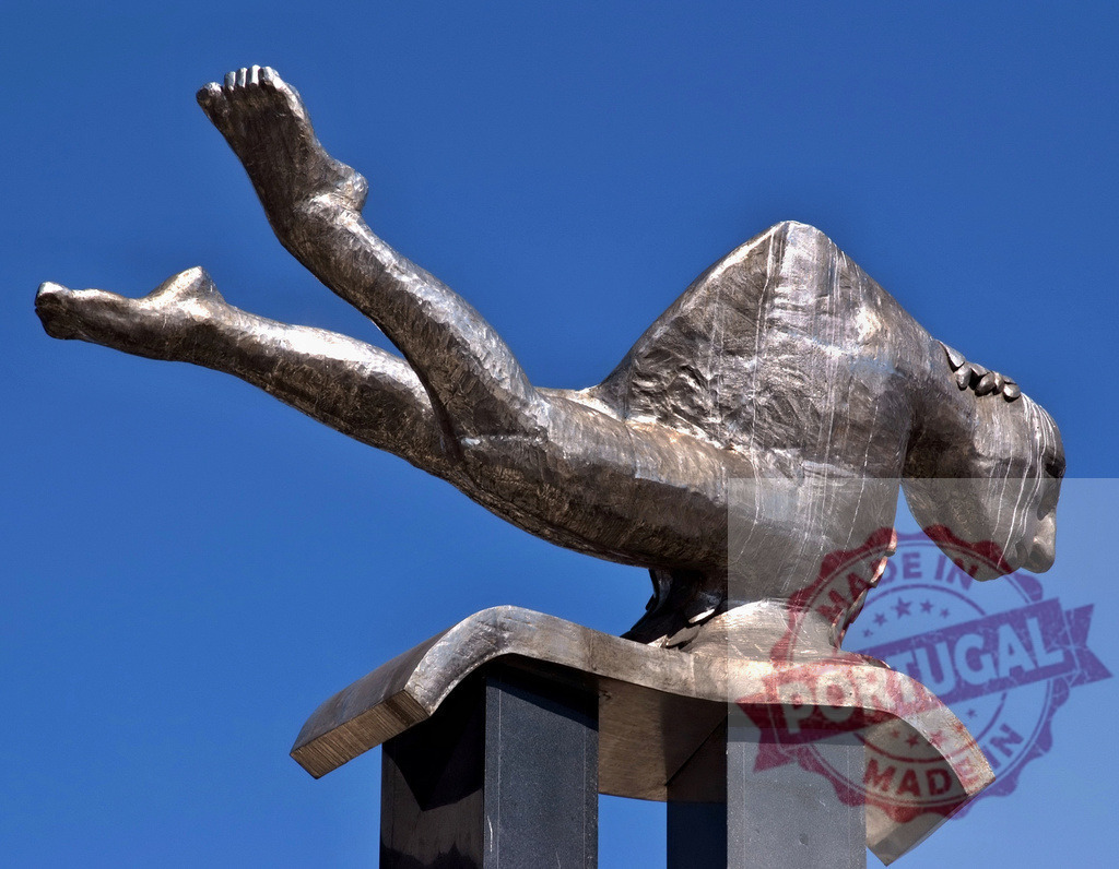 Bronze diving sculpture representing human movement against blue sky. Galicia - Spain | Abstract bronze sculpture depicting a falling human figure, symbolizing freedom and motion - Realisiert mit Pictrs.com