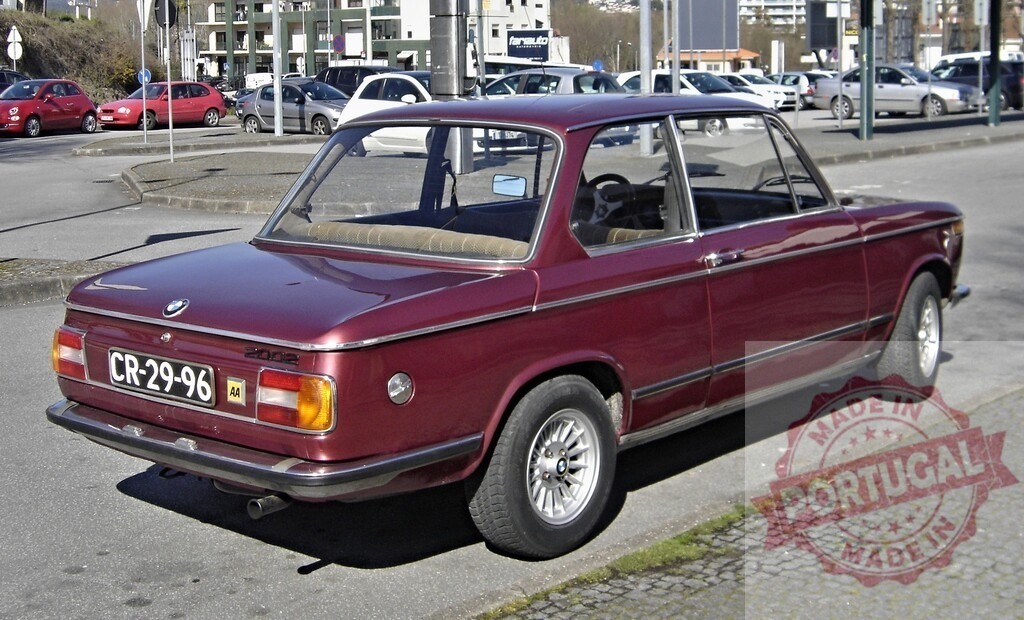 Classic BMW 2002tii parked on a city street | Vintage BMW 2002tii automobile parked on a paved street in an urban environment - Realized with Pictrs.com