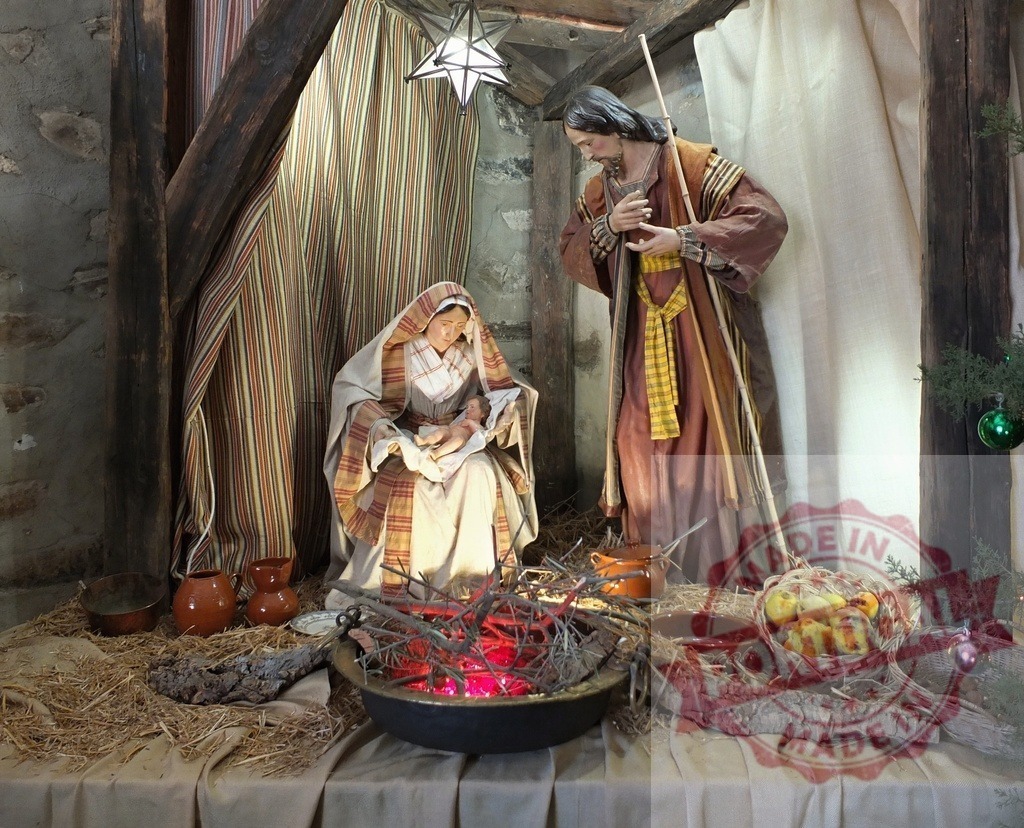 Nativity scene depicting Jesus, Mary and Joseph with Christmas decorations | Christmas nativity scene showing baby Jesus, Mary and Joseph with fire, food, straw and Christmas decorations - Realisiert mit Pictrs.com
