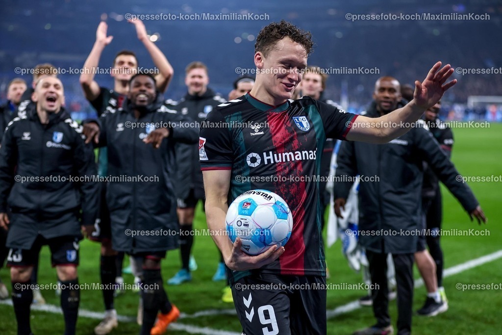 S0401022501108 | 01.02.2025, Fußball, FC Schalke 04 - 1. FC Magdeburg, 2.. Fußball Bundesliga, 20. Spieltag, Veltins-Arena Gelsenkirchen, Saison 2024 2025: Freude und Emotionen nach dem 5:1 Sieg für Magdeburg. Der vierfache Torschütze Martijn Kaars (1.FC Magdeburg #9)  hat sich den Spielball gesichert und steht jubelnd und tanzend mit der Mannschaft vor den feiernden Fans. DFB regulations prohibit any use of photographs as image sequences and or quasi-video.