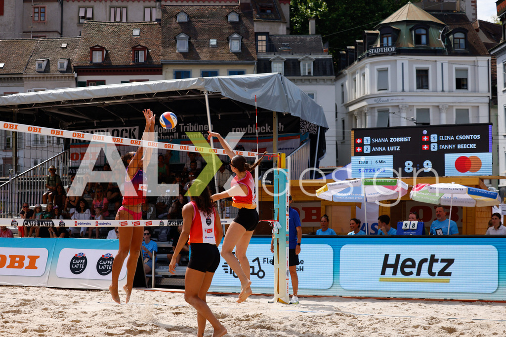 Obi BeachTour 2026 - Basel | BASEL, SWITZERLAND - JULY 17: ANNA LUTZ (SUI) attack / spike against ELENA CSONTOS (SUI) block during the Obi BeachTour 2026 match between ZOBRIST / LUTZ (SUI) and CSONTOS / DEECKE (SUI) at Barfüsserplatz on July 17, 2026 in Basel, Switzerland. - Realisiert mit Pictrs.com