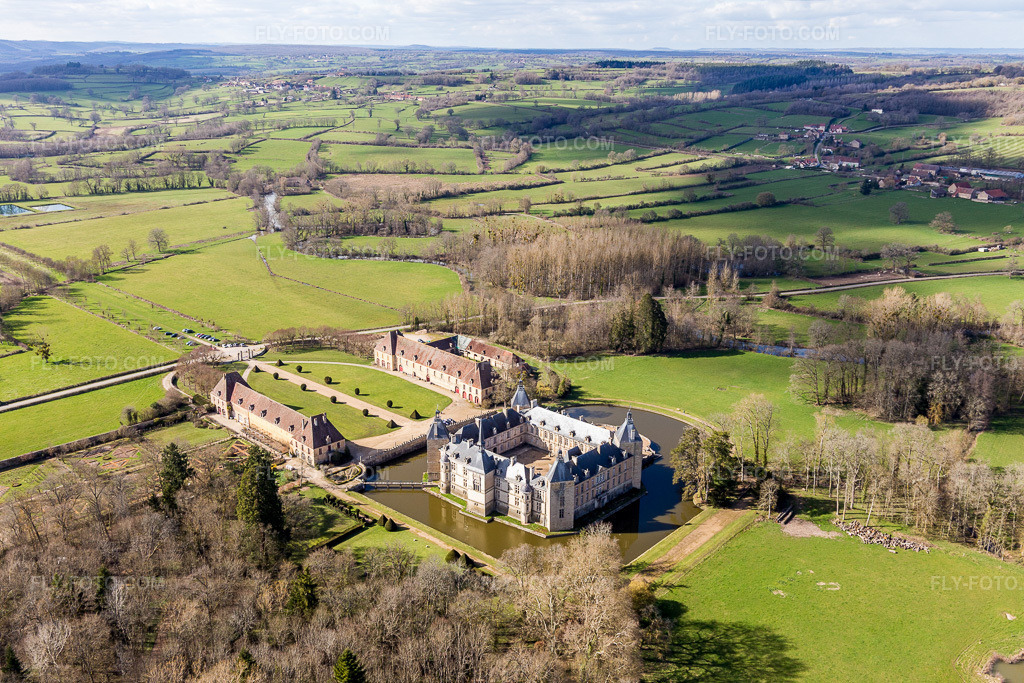 Aerial view: Buildings and castle park facilities of the moated castle Sully in Sully in the state Saone et Loire, France. – Photo: IMG_105441.jpg taken on 04/01/2018 by Werner Riehm/FLY-FOTO.com – Resolution of the original: 5472 x 3648 px