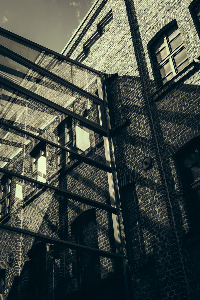 Echoes in Brick and Glass – Innenhafen Duisburg | Eine atmosphärische Architektuserie aus dem Duisburger Innenhafen. Die vier Motive zeigen das Zusammenspiel von historischem Backstein, modernen Glaselementen, Licht, Schatten und Spiegelungen. - Realisiert mit Pictrs.com