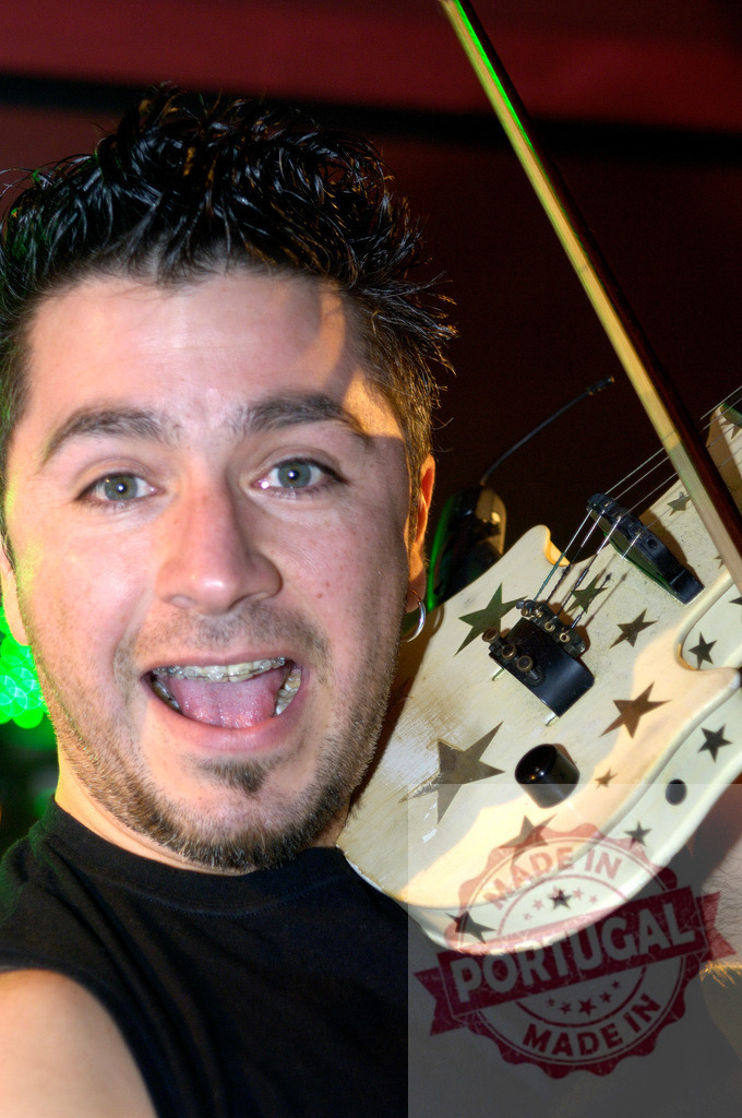 Musician playing electric violin with star decorations during live performance | Musician enthusiastically playing decorated electric violin during a live performance on stage - Realisiert mit Pictrs.com