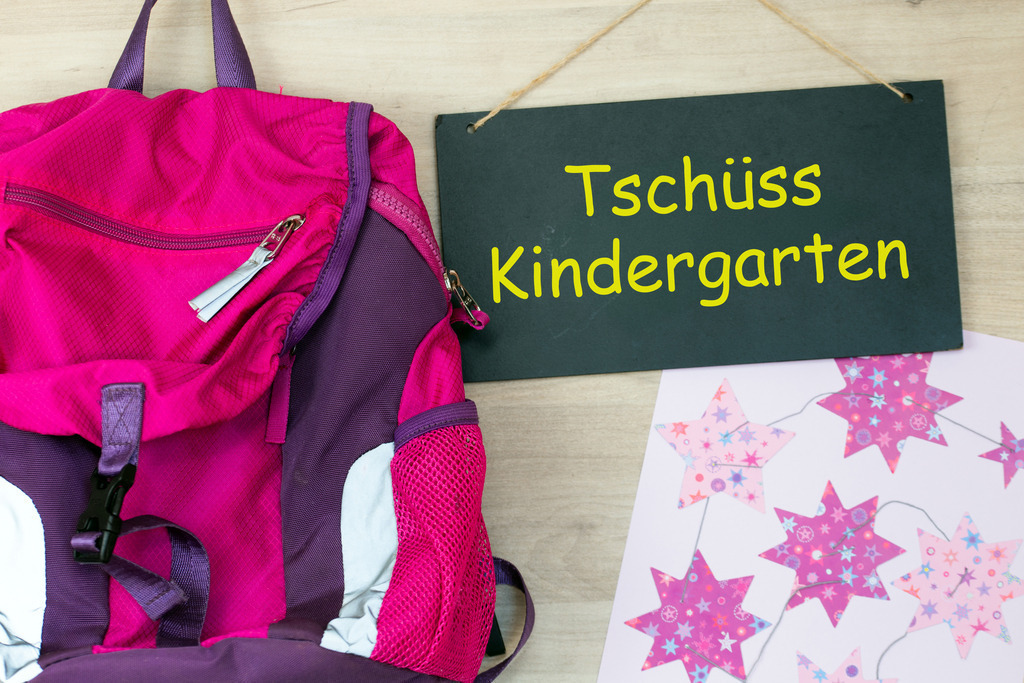 Tschüss Kindergarten: Bild zum Ende der Kindergartenzeit | Tschüss Kindergarten: Neben einem Rucksack und einem gebastelten Bild hängt ein Schild mit hinzugefügtem Text TSCHÜSS KINDERGARTEN (Symbolbild) - Realisiert mit Pictrs.com