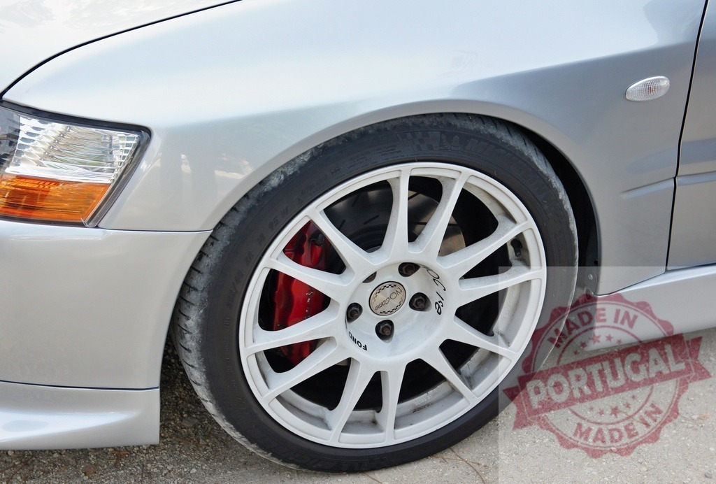 Close-up of white alloy wheel rim and red brake caliper on silver sports car | Stylish white alloy wheel rim with red brake caliper adds sporty touch to silver tuned car - Realisiert mit Pictrs.com