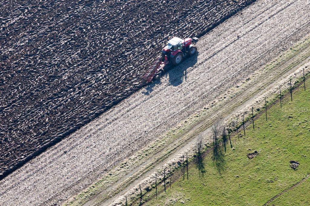 Vue aérienne: Labour et déplacement de la terre à l'aide d'un tracteur équipé d'une charrue sur les champs agricoles à Lampertsloch dans le département Bas Rhin, France. Photo: IMG_37402.jpg prise le 07/02/2011 par Werner Riehm/FLY-FOTO.eu – Résolution de l'original: 3700 x 2466 px