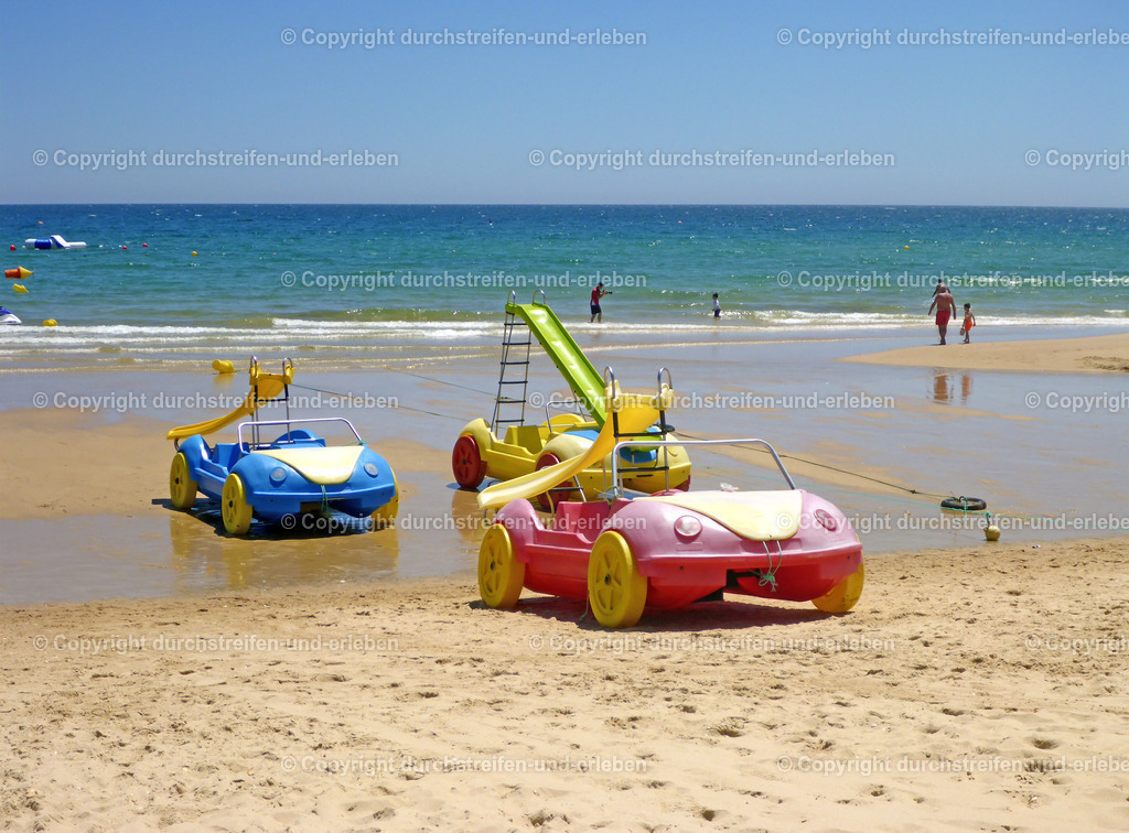 Spielzeugautos für Kinder Praia da Manta Rota, Algarve | An der Praia da Manta Rota warten große Autos auf dem Strand auf die Kinder der Strandbesucher.  - Realisiert mit Pictrs.com