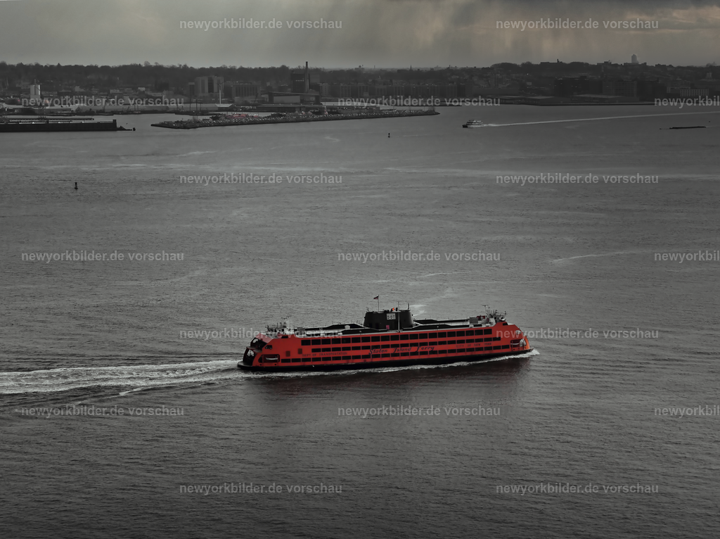Roter Akzent in der Weite – Staten Island Ferry aus der Luft | Aus der Luft öffnet sich ein Panorama, das die Weite des Wassers und die Kraft der Stadt vereint. Die rote Staten Island Ferry sticht markant aus dem Wasser des Hudson hervor und setzt einen lebendigen Kontrast zur Kulisse rund um Manhattan.