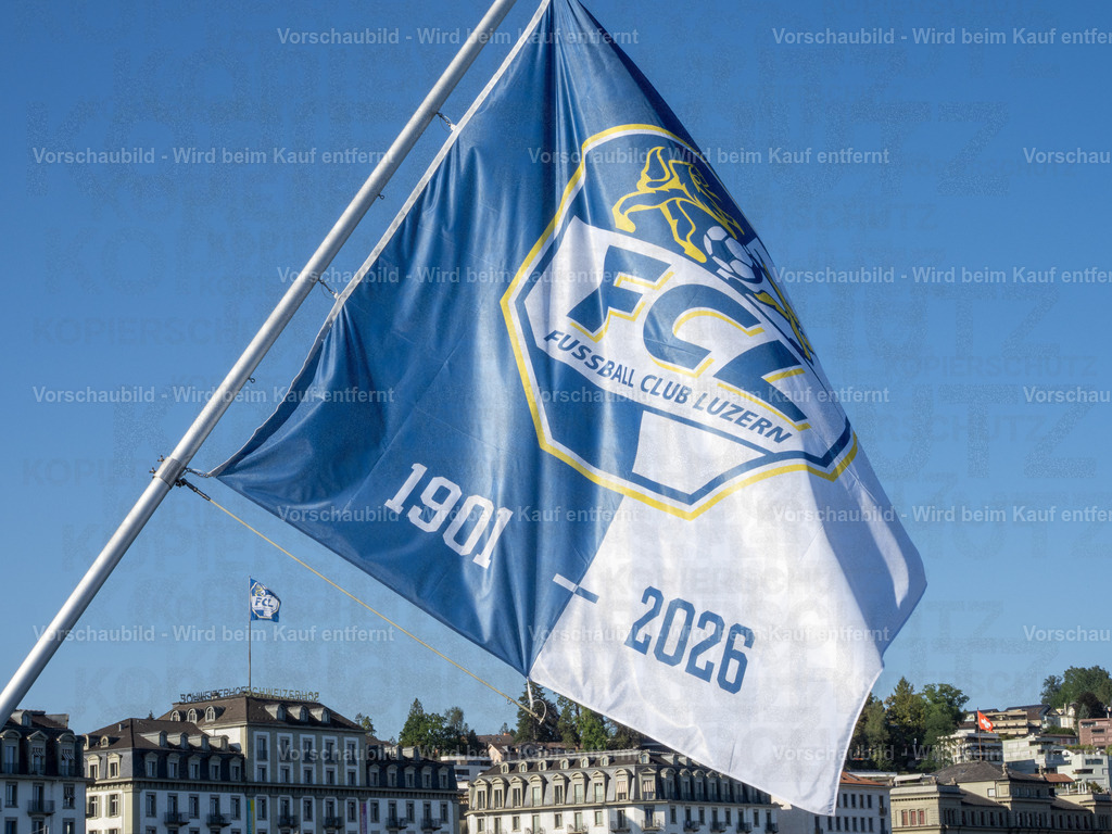 125 Jahre FCL – Luzern in Blau-Weiss | Die blau-weissen Fahnen wehen an der Seebrücke im Wind und zelebrieren das 125-Jahre-Jubiläum des FC Luzern. Dahinter erstreckt sich die Kulisse der Luzerner Seepromenade mit dem traditionsreichen Hotel Schweizerhof. - Realisiert mit Pictrs.com