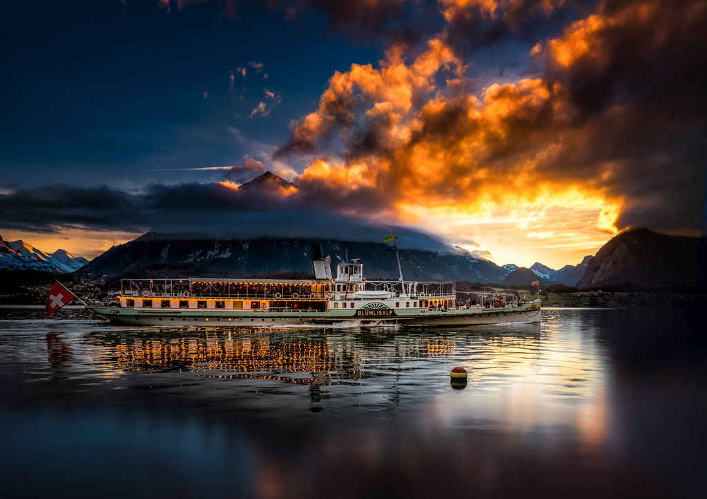 Winterdampf | Das Dampfschiff "Blümlisalp" verkehrt im Winter nur über die Feiertage; hier am 30. Dezember 2021 nach Gunten Richtung Oberhofen. 
Das Bild ist eine Kombination aus einer Langzeitbelichtung für den Niesen, die Sonnenuntergangsstimmung und Teile des See, und einer kürzeren Belichtung für das Schiff und dessen Reflexion im Wasser.

In winter, the "Blümlisalp" steamboat only operates on public holidays; here on December 30, 2021 from Gunten in the direction of Oberhofen.
The image is a combination of a long exposure for the Niesen, the mood of the sunset and parts of the lake, and a shorter exposure for the ship and its reflection in the water. - Realisiert mit Pictrs.com