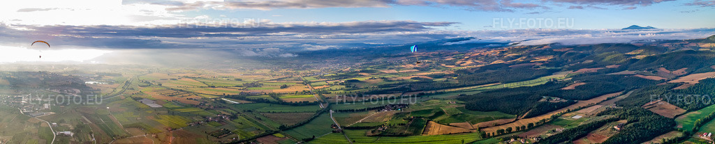 Vue aérienne: Panorama du lever de soleil sur le paysage avec des parapentes à Sinalunga dans le département Siena, Italie. Photo: IMG_43654-Bearbeitet.jpg prise le 28/07/2011 par Werner Riehm/FLY-FOTO.eu – Résolution de l'original: 13579 x 2740 px