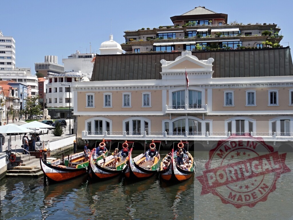 Aveiro canals with traditional moliceiro boats docking. Aveiro - Portugal | Moliceiro boats carrying tourists on a canal with historic architecture in Aveiro, Portugal - Realisiert mit Pictrs.com