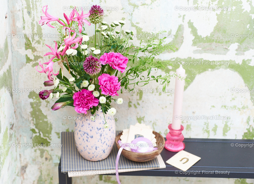 Pinker Blumenstrauß vor grün-weißer Wand | Pinker Blumenstrauß vor grün-weißer Wand in Vase mit blauen Tupfen - Realisiert mit Pictrs.com