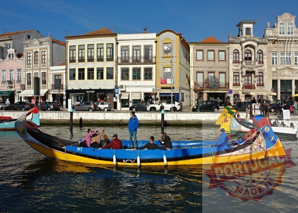 Moliceiro boat carrying tourists on Aveiro canal | Moliceiro boat carrying passengers on a canal with colorful buildings along the waterfront - Realisiert mit Pictrs.com
