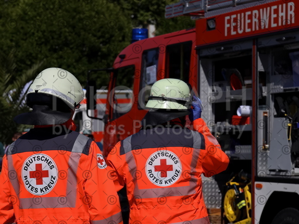 Sanis | DRK-Sanitäter vor einem Feuerwehrfahrzeug während einer Übung.