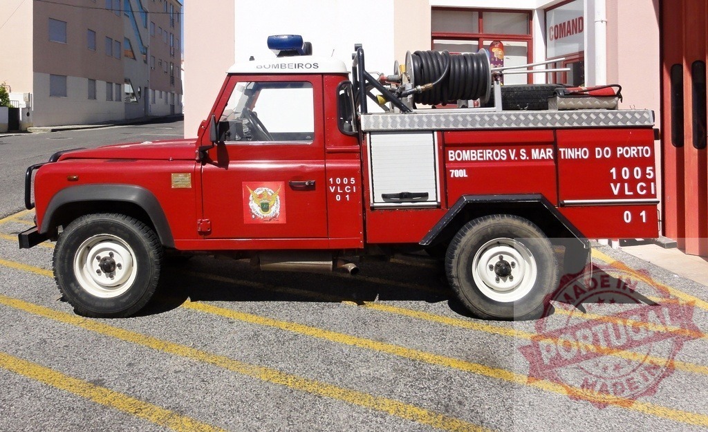 Red Land Rover fire truck parking at Bombeiros station | Red Land Rover fire truck with equipment for fighting fires parked at a Bombeiros station - Realisiert mit Pictrs.com