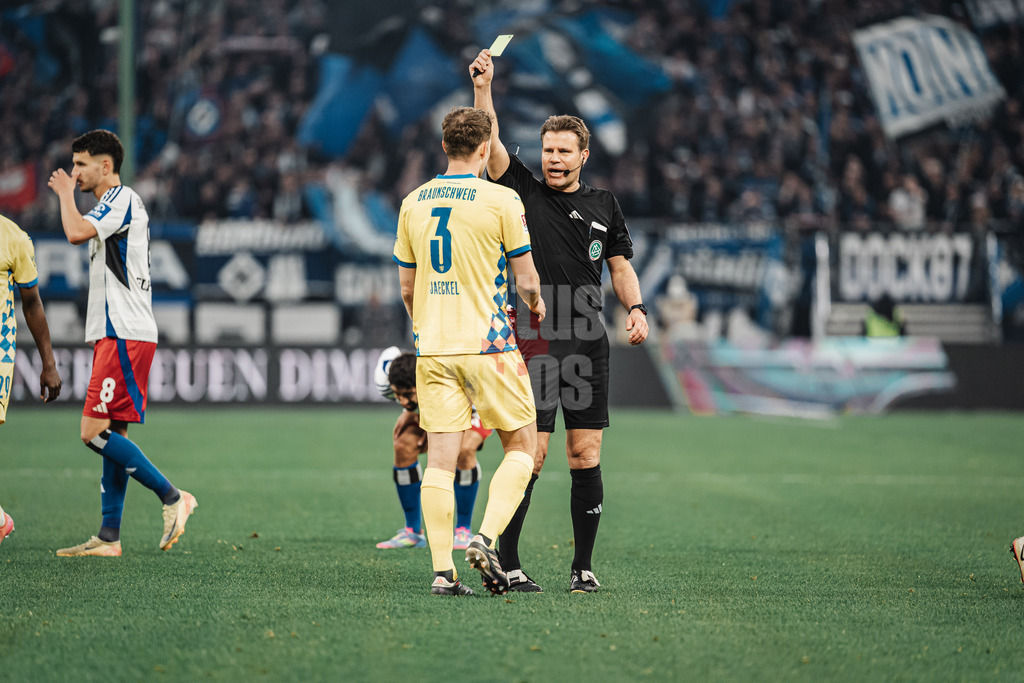 Fußball | Männer | Saison 2024/2025 | 2. Fußball-Bundesliga | 29. Spieltag | Hamburger SV vs. Eintracht Braunschweig | 11.04.2025 | Paul Jaeckel (#3, Eintracht Braunschweig) links sieht von Schiedsrichter Dr. Felix Brych die Gelbe Karte