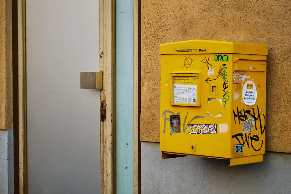 Alter verschmierter gelber Briefkasten an der Wand | Wien, Austria - March 12, 2021: Alter verschmierter gelber Briefkasten an der Wand, daneben eine Türe. - Realisiert mit Pictrs.com