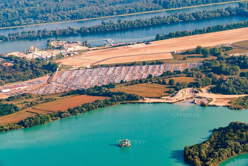 Vue aérienne: ARCHICUB - Aire de stationnement pour l'importation des camions et des voitures du Walon, de l'autre côté du lac de baignade à Lauterbourg dans le département Bas Rhin, France.Photo: P1000845.jpg prise le 15/09/2014 par Werner Riehm/FLY-FOTO.euRésolution de l'original: 5472 x 3648 pxSolutions logistiques pour l'industrie: