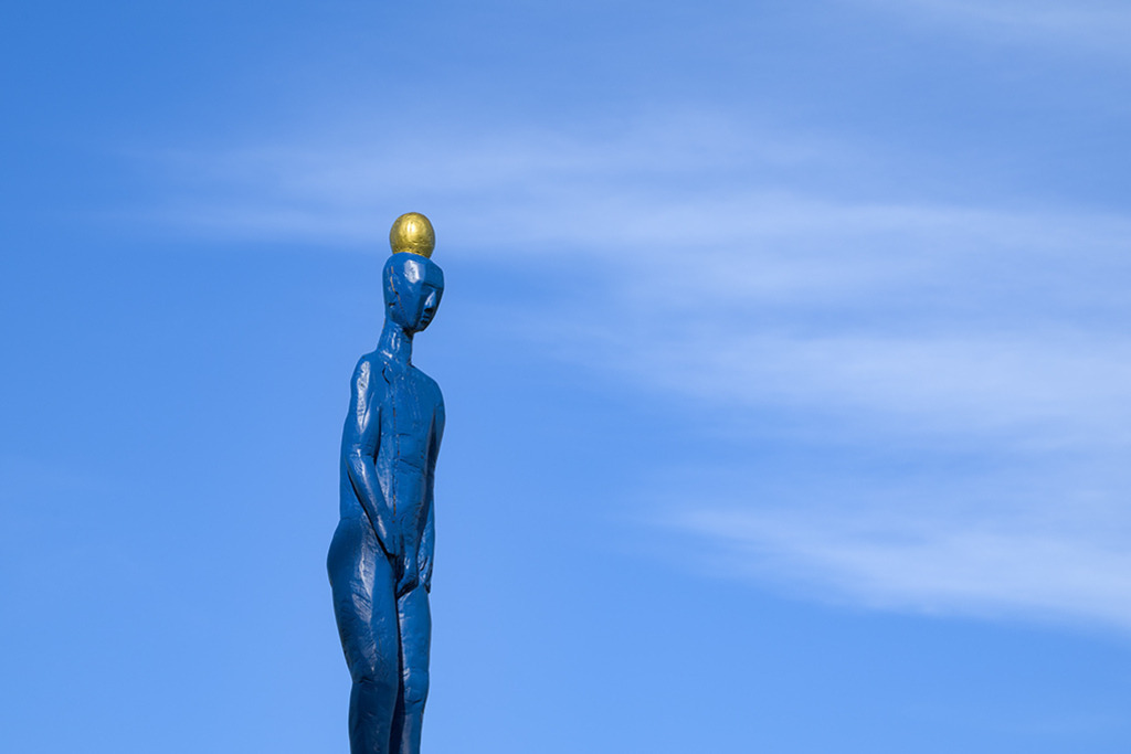 Skulptur Unverzagtheit | Die Skulptur Unverzagtheit stammt von dem Künstler Jürgen Wilms, sie ist Teil eines Trios aus drei Skulpturen in der Stadt Meldorf in Schleswig-Holstein. Eine mystische Lebendigkeit erlangt die Skulptur durch die federleichten Wolken im Hintergrund. — Auflösung des Originals: 8256 x 5504 px. - Realisiert mit Pictrs.com