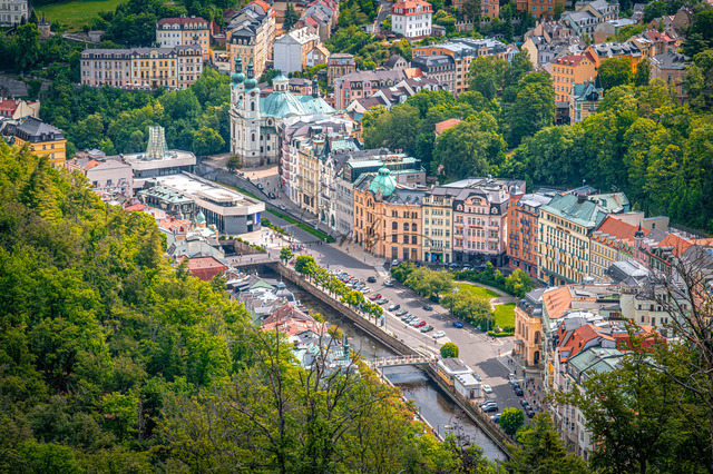 In Karlsbad sieht man ein Panorama von bunten Gebäuden und einem Fluss. Die Stadt hat viele Bäume und Menschen auf der Straße. Es ist ein aktiver Tag im Zentrum | In Karlsbad sieht man ein Panorama von bunten Gebäuden und einem Fluss. Die Stadt hat viele Bäume und Menschen auf der Straße. Es ist ein aktiver Tag im Zentrum. - Realisiert mit Pictrs.com