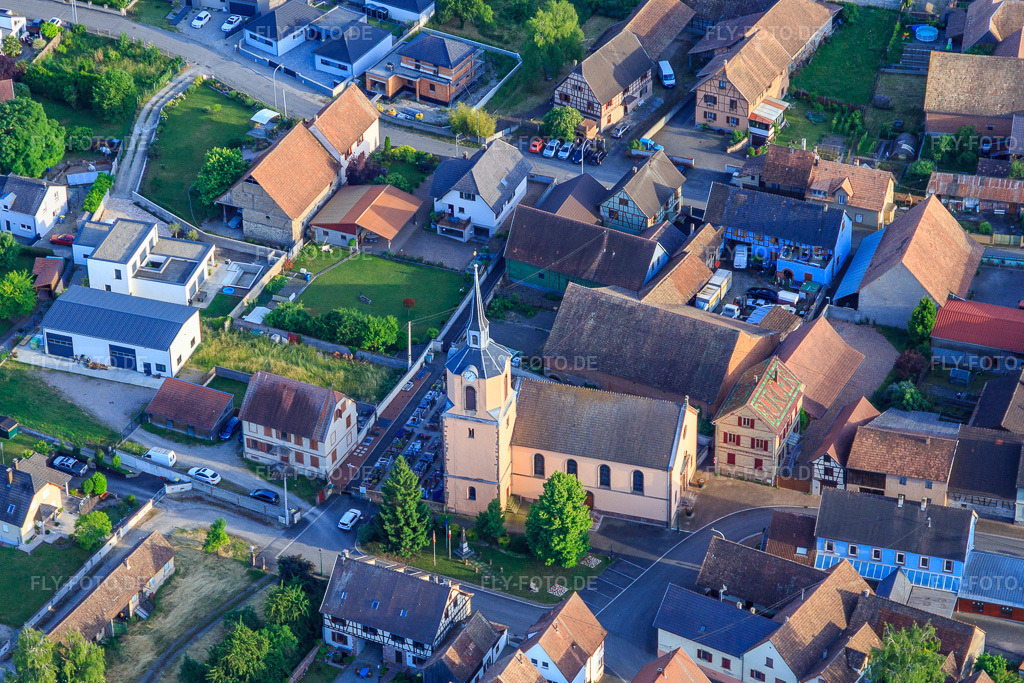 Luftbild: Kirche und Mairie in Dorfmitte in Hessenheim im Bundesland Bas-Rhin in Frankreich. Foto: IMG_147371.jpg vom 29.05.2025 durch Werner Riehm/FLY-FOTO.de