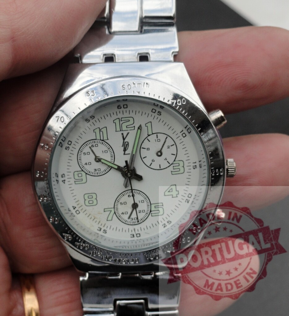 Person holding stainless steel chronograph wristwatch | Hand holding a silver metal chronograph wristwatch with white dial and metal band - Realisiert mit Pictrs.com