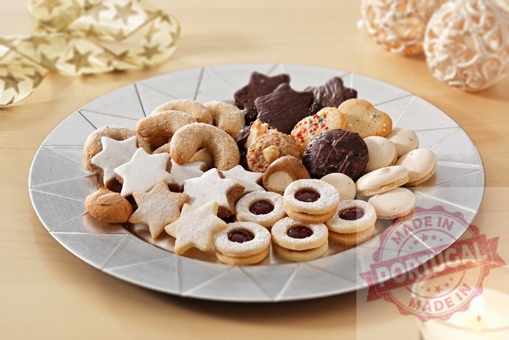 Christmas cookies decorating silver plate with candle and ribbon creating festive atmosphere | Various christmas cookies arranged on silver plate, candle and ribbon adding to festive atmosphere - Realized with Pictrs.com