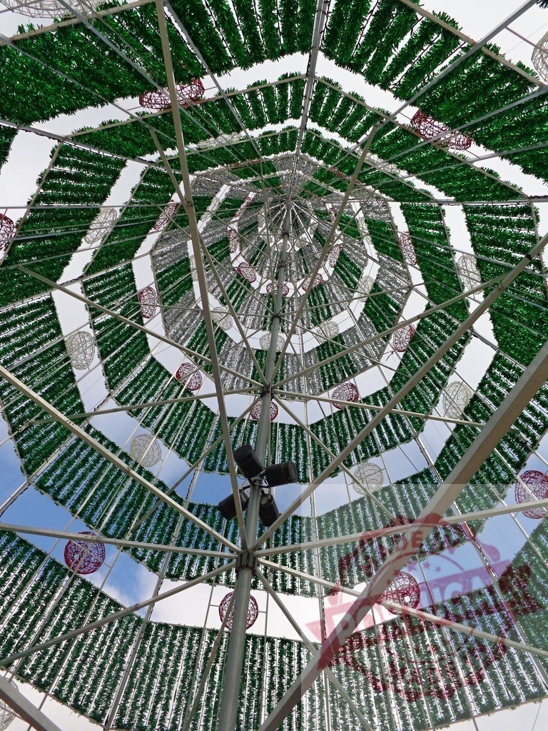 Low angle view of christmas tree metal structure with green and white decorations | Metal structure of a large christmas tree decorated with green and white tinsel seen from below - Realized with Pictrs.com