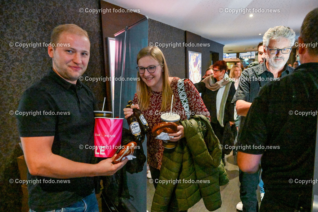 Wels_ Star Movie_ Rehragoutrendezvous_ 09.08.2023-20 | 09.08.2023, Wels, AUT, Star Movie, Kino, Rehragoutrendezvous, Kinopremiere, im Bild Kinobesucher stroemen in den Saal mit Brezen und Bier