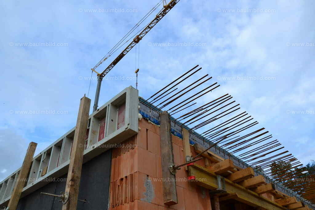 Anschlussbewehrung Balkonplatte | Geschoßdecke mit Wärmedämmelement für auskragenden Balkon, im Hintergrund Baukran und blauer Himmel mit Wolken