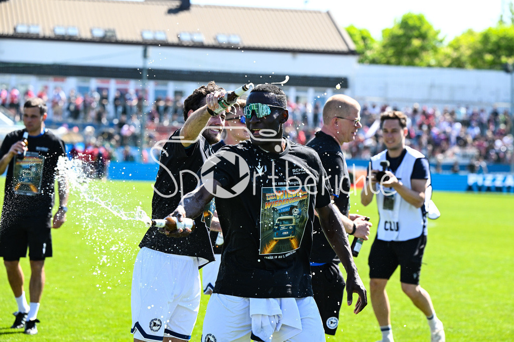 SpVgg Unterhaching - Arminia Bielefeld | die Mannschaft aus Bielefeld feiert zusammen mit den Fans dein Sieg und den Aufstieg in Unterhaching / Bierdursche / Bier / Freude / Happy / Gluecklich / 3. Liga: SpVgg Unterhaching - Arminia Bielefeld, Uhlsport Park am 11.05.2025 / Merveille BIANKADI (Arminia Bielefeld 17)
