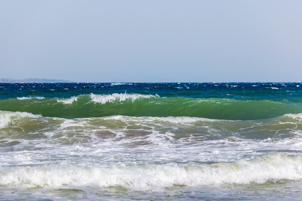 Wandbild: Wellen in klarem Ostseelicht | Die Ostsee zeigt sich in einem Moment voller Klarheit und Bewegung: sanfte bis kraftvolle Wellen rollen in transparenten Blau‑ und Grüntönen heran, während das Licht des Himmels die Wasseroberfläche zum Schimmern bringt. Der Horizont liegt ruhig und weit, wodurch die Dynamik der Wellen noch eindrucksvoller wirkt. Dieses Wandbild verbindet die frische Energie der Küste mit einer hellen, natürlichen Leichtigkeit und bringt die besondere Atmosphäre eines klaren Ostseetages in den Raum. - Realisiert mit Pictrs.com