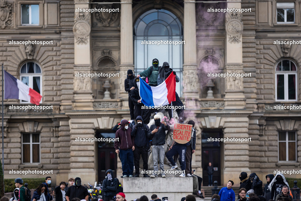 _B7A6589 | Strasbourg, France, 24 octobre 2026. Des manifestants affrontent les forces de l’ordre lors d’une mobilisation dans le centre-ville de Strasbourg. Des policiers interviennent pour disperser des groupes de manifestants, tandis que des gaz lacrymogènes sont utilisés. Des affrontements, des jets de projectiles et des dégradations sont observés dans plusieurs rues. Des barricades et des véhicules en feu témoignent de la tension qui règne en marge de la mobilisation. - Realisiert mit Pictrs.com