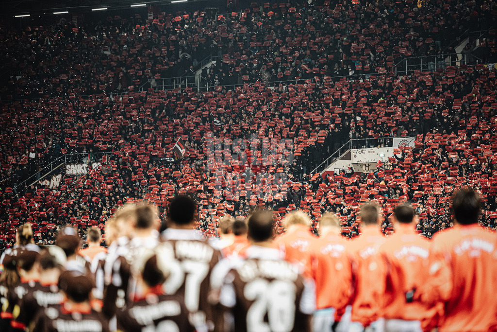 Fußball | Männer | Saison 2025/2026  | Fußball-Bundesliga | 11. Spieltag | FC St. Pauli vs. 1. FC Union Berlin | 23.11.2025 | Die Mannschaften laufen ins Stadion ein, auf den Tribünen werden Schilder mit no IMK hochgehalten No International Migration Conference gegen Internationale Migrationskonferenz