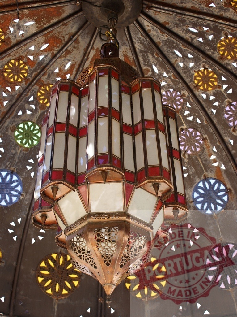 Moroccan hanging lantern illuminating traditional decorative ceiling | Ornate metal and glass lantern suspended against a rustic domed ceiling with colorful light patterns - Realisiert mit Pictrs.com