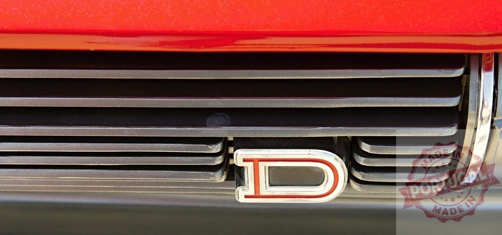 Red car showing chrome grill with D emblem | Red classic car showing an iconic chrome grill and D emblem detail - Realized with Pictrs.com