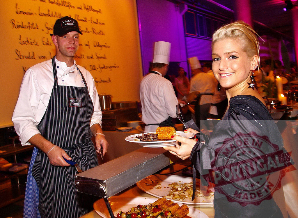 Chef serving corn on the cob and grilled meat to elegant woman at buffet | Chef serving grilled meat and corn on the cob to an elegant woman at a buffet, during a catered event - Realized with Pictrs.com