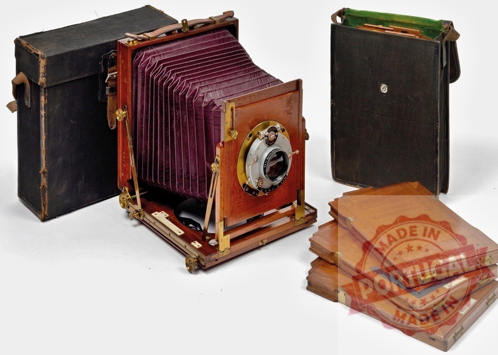 Vintage wooden field camera with bellows and accessories on white | Vintage wooden field camera with bellows, lens, dark slides, and carrying cases - Realized with Pictrs.com