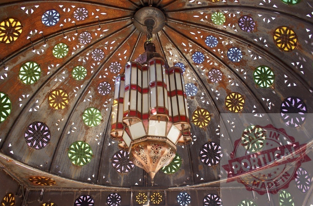 Moroccan style lantern hanging under ornate dome ceiling | Ornate Moroccan style lantern hanging from a decorative dome ceiling with colorful stained glass - Realized with Pictrs.com